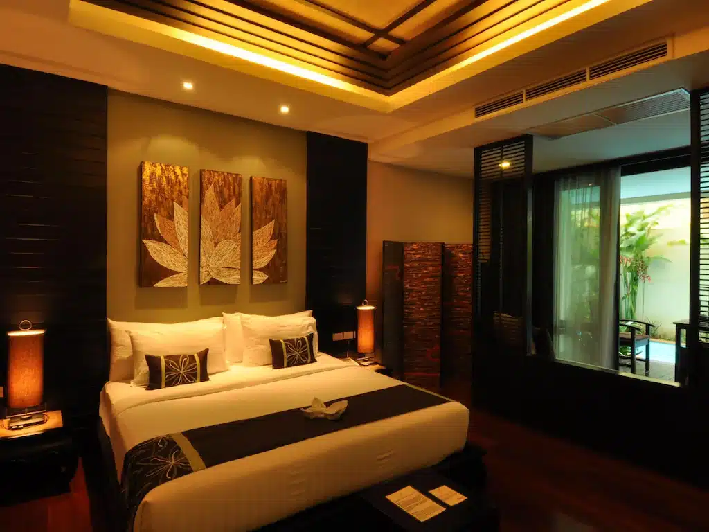 ห้องนอนที่มีเตียงขนาดใหญ่และหน้าต่างบานใหญ่ที่มีพระพุทธชินราช รูปพระพุทธชินราช
