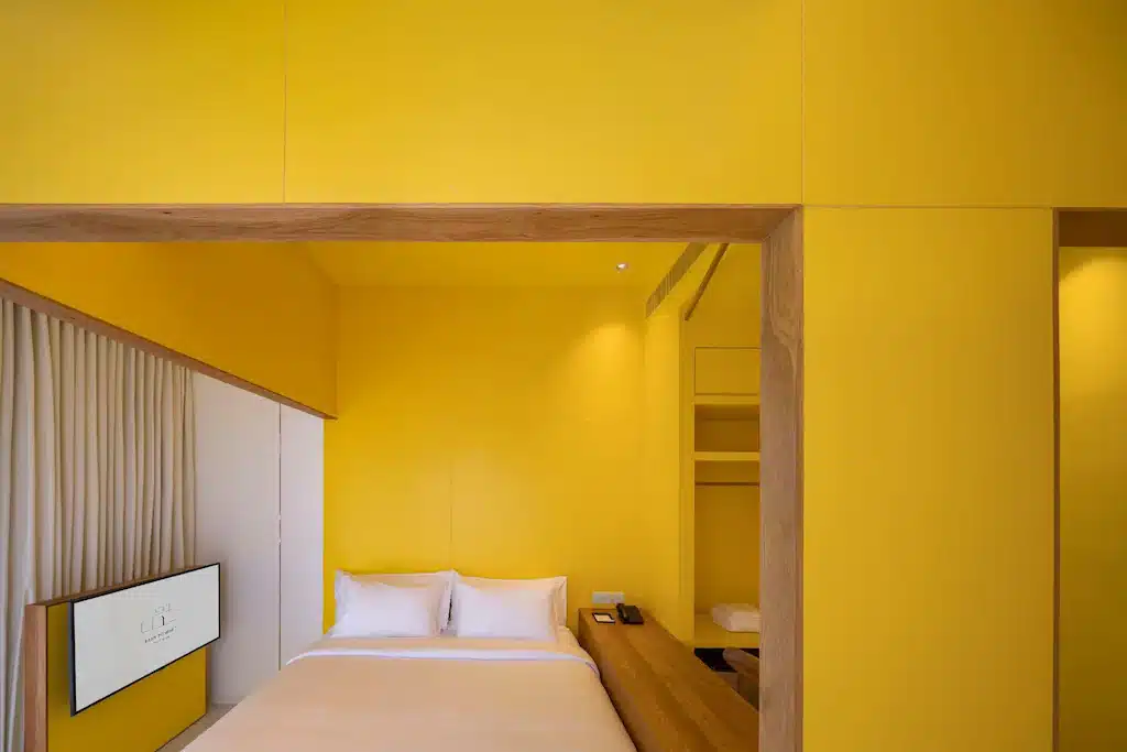 ห้องสีเหลืองพร้อมเตียงและทีวีอยู่ในวัดอรุณราชวรารามราชวรมหาวิหาร วัดไชยวัฒนาราม