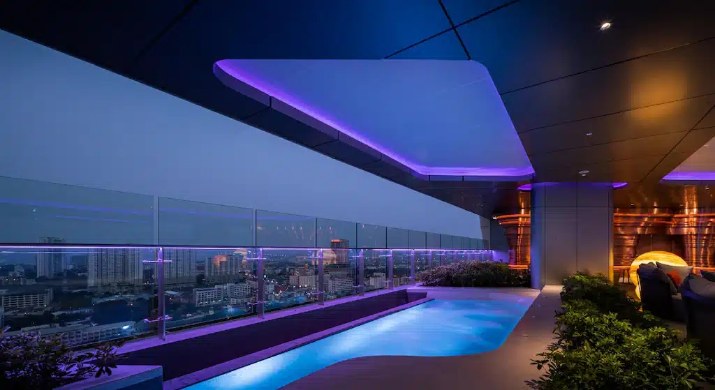 โรงแรม 5 ดาวในเมืองพัทยาพร้อมสระว่ายน้ำบนชั้นดาดฟ้าที่มองเห็นวิวเมืองที่สว่างไสวด้วยแสงสีม่วง โรงแรมพัทยา 5 ดาว