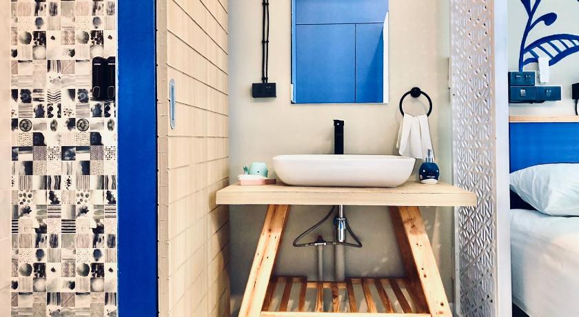 ห้องน้ำทับสะแกที่มีผนังสีฟ้าขาวและอ่างล้างจาน ที่พักทับสะแก