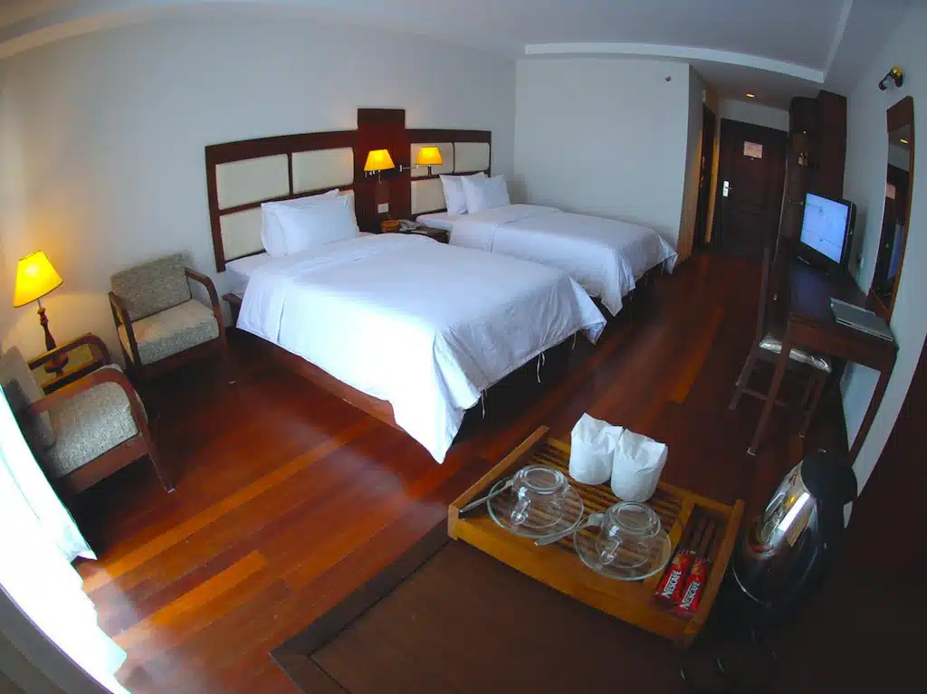 ห้องพักในโรงแรมที่มีสองเตียงและโต๊ะ ที่เที่ยวมุกดาหาร