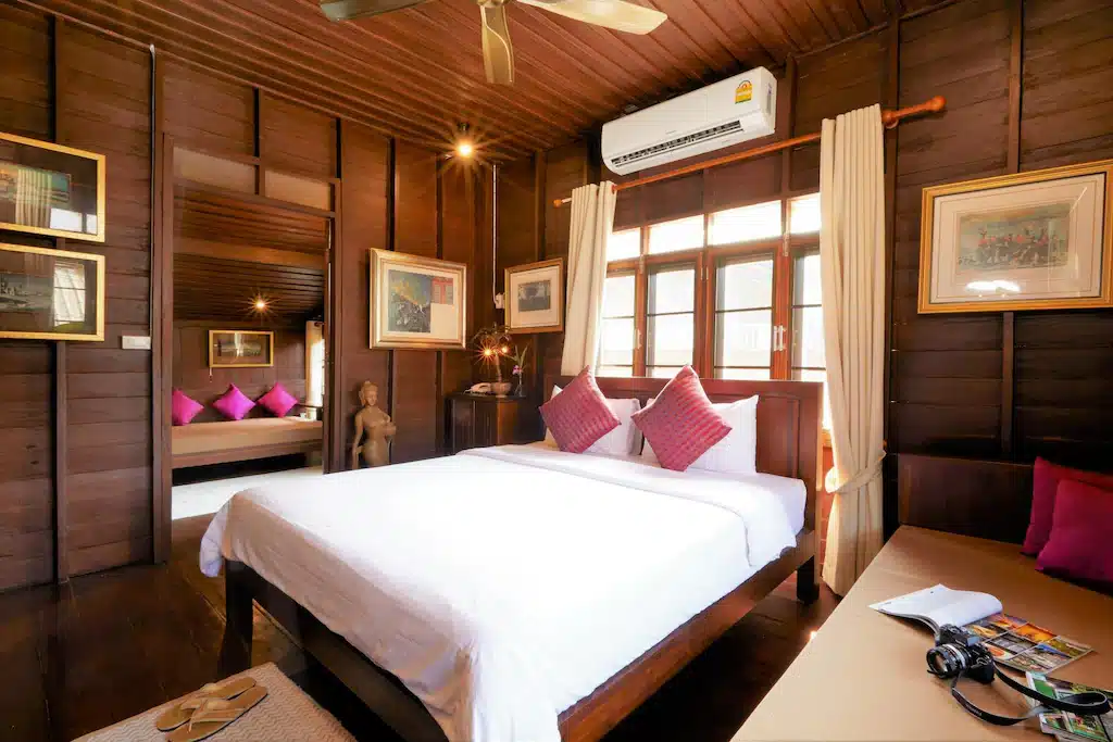 ห้องนอนแสนสบายพร้อมผนังไม้และพัดลมเพดานมีให้บริการที่โรงแรมใกล้ถนนคนเดินปาย ที่พักปาย