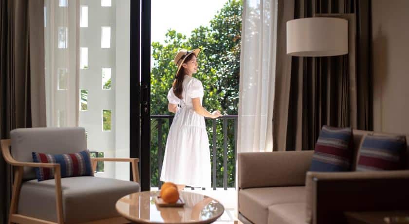 หญิงชุดขาวยืนอยู่นอกห้องในโรงแรมแห่งหนึ่งในเมืองน่าน
