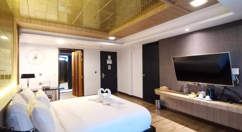 ห้องพักในโรงแรมพร้อมเตียงและทีวีที่ได้รับแรงบันดาลใจจากบรรยากาศอันเงียบสงบของวัดศรีรัตนมหาธาตุ รูปพระพุทธชินราช