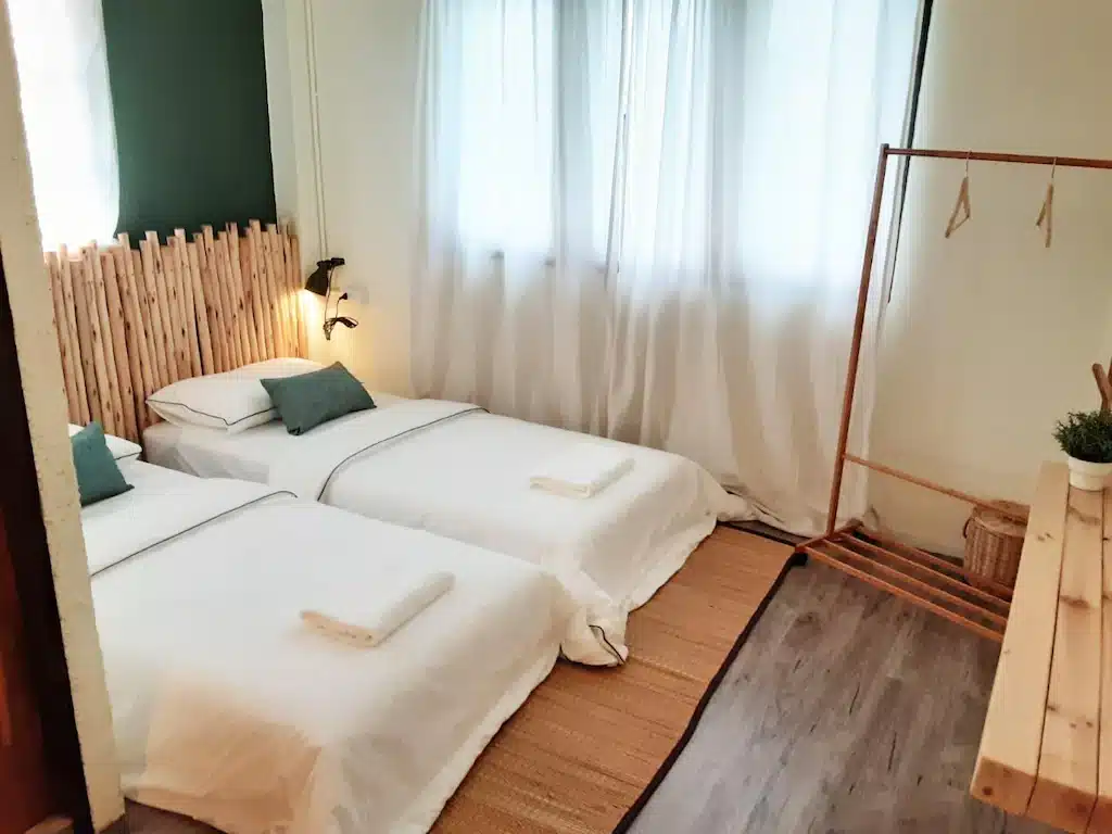 โรงแรมสัตหีบ ที่มีเตียง 2 ตู้เสื้อผ้าและหัวเตียงไม้