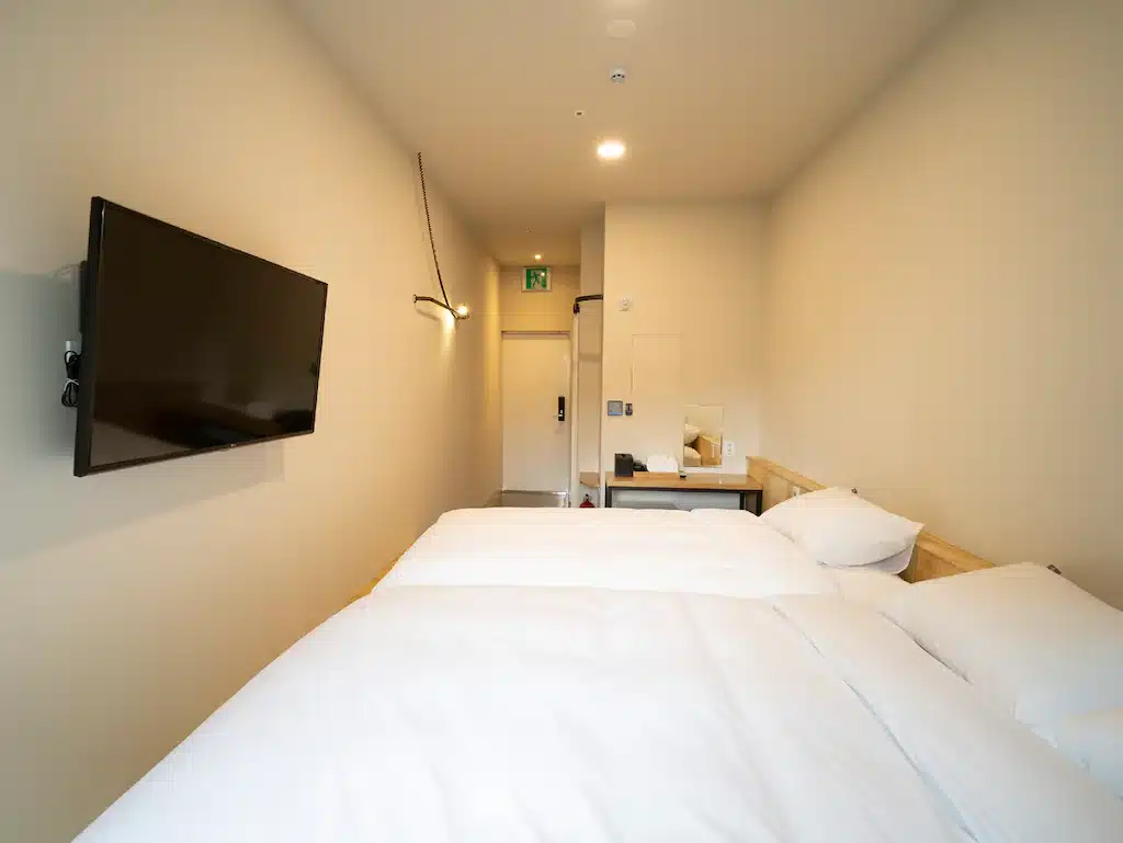 ห้องพักในโรงแรมแสนสบายในเกาหลีใต้พร้อมเตียง 2 เตียงและทีวี ที่เที่ยวเกาหลี