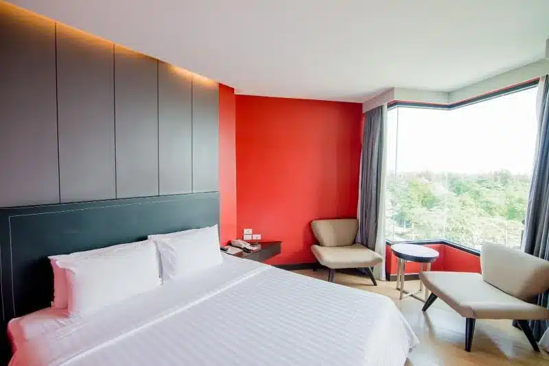 ห้องรีสอร์ทโขงเจียมที่มีผนังสีแดงและเตียงนอน บางแสน