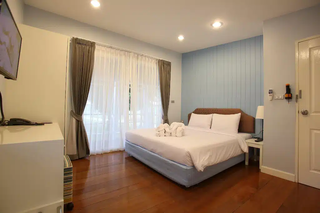 ห้องนอนที่มีผนังสีฟ้าและเตียงสีขาว ตั้งอยู่ที่ โขงเจียมริมโขง บางแสน