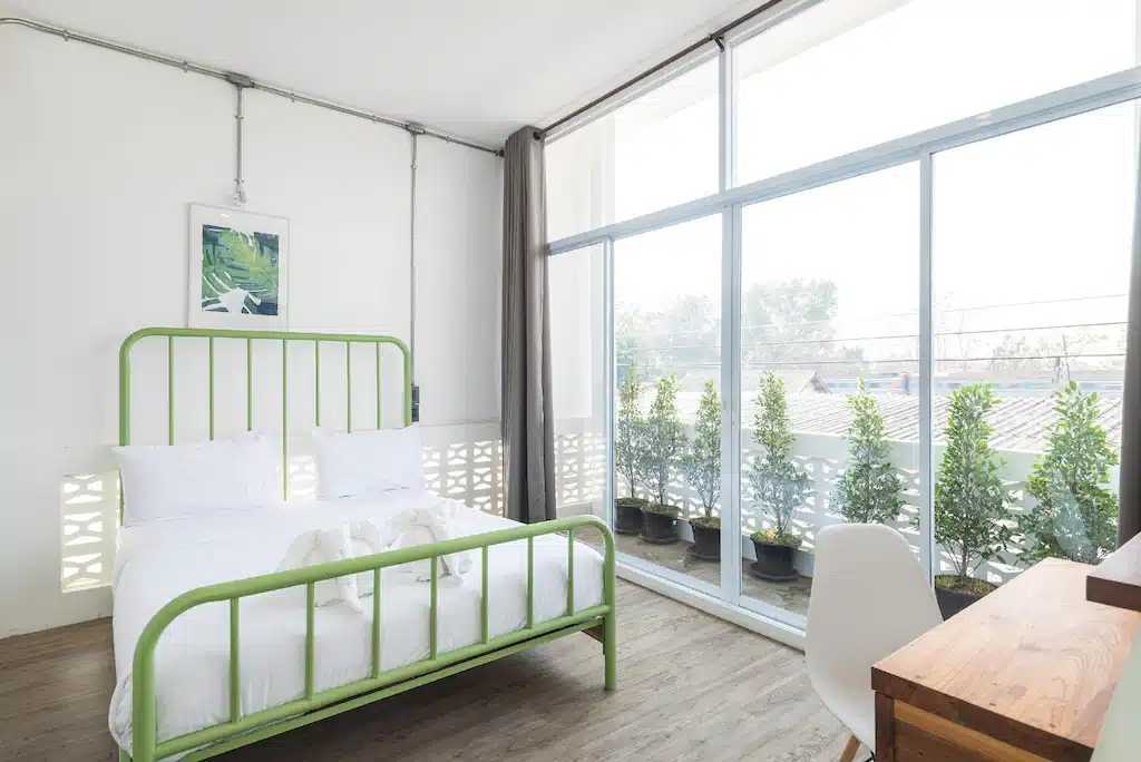 ห้องนอนที่มีเตียงนอน สีเขียว เที่ยวลำปาง