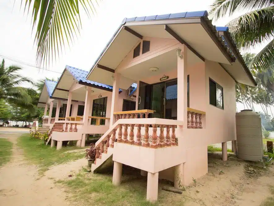บ้านสีชมพูหลังเล็กพร้อมระเบียงและต้นปาล์มที่หาดแหลมสิงห์ ที่พักหาดแหลมสิงห์