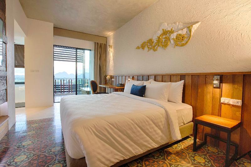 เตียงในห้องที่โรงแรมในกรุงเทพฯ พร้อมด้วยคุณสมบัติเมืองกาญจนบุรี ที่พักเมืองกาญจนบุรี