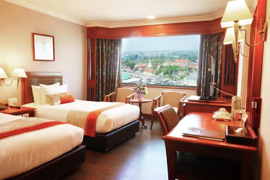 2 เตียงในห้องพักโรงแรมพร้อมวิวเมืองในเที่ยวงานพิษณุโลก ที่เที่ยวพิษณุโลก