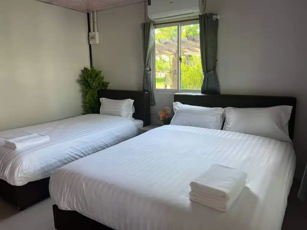 โรงแรมท่าศาลาที่มีสองเตียงและผ้าปูที่นอนสีขาวในห้องเล็กๆ ที่พักโขงเจียมริมโขงรีสอร์ทโขงเจียม