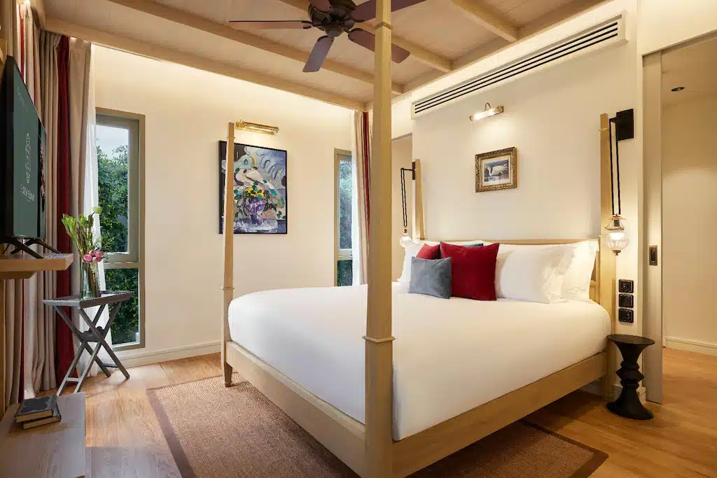 ห้องนอนริมชายหาดพร้อมเตียงสี่เสาและพัดลมเพดาน ที่พักหาดสวนสน