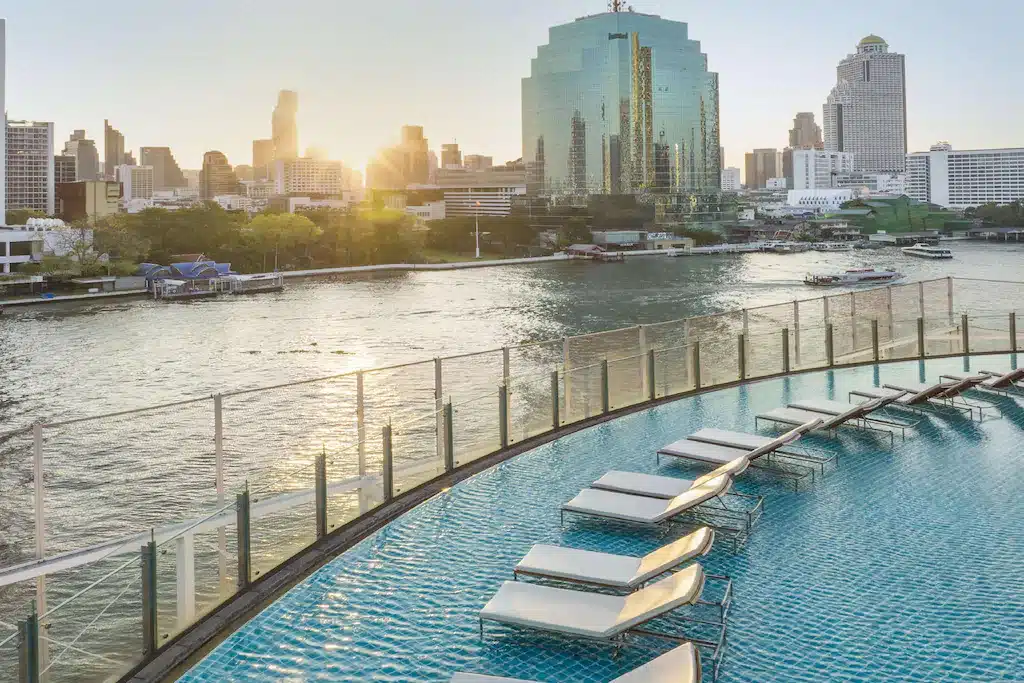 โรงแรมหรูระดับ 5 ดาวในกรุงเทพฯ พร้อมสระว่ายน้ำและเก้าอี้นั่งเล่นพร้อมทิวทัศน์เมืองอันตระการตา โรงแรม 5 ดาว กรุงเทพ