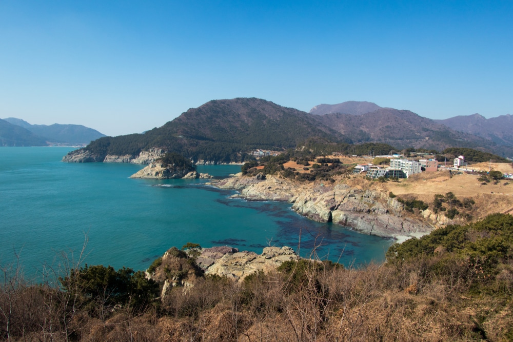 ทิวทัศน์ของทะเลสีฟ้าที่มีภูเขาเป็นฉากหลัง เหมาะสำหรับนักท่องเที่ยวที่กำลังมองหาสถานที่ท่องเที่ยว ที่เที่ยวเกาหลี ที่สวยงามในเกาหลี