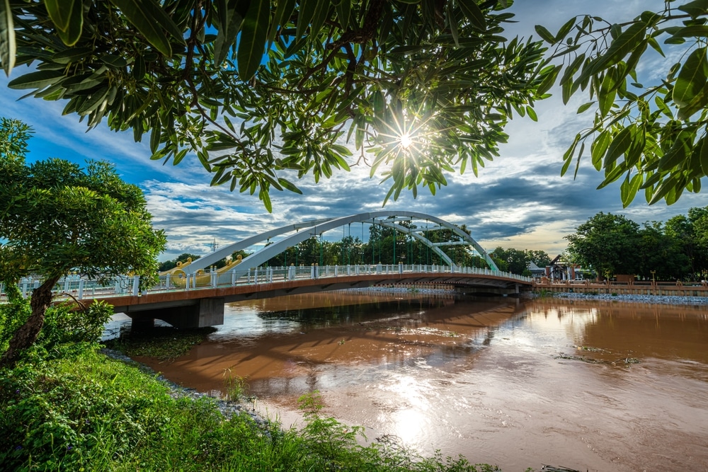 สะพานข้ามแม่น้ำที่มีต้นไม้เป็นฉากหลังใกล้กับวัดศรีรัตนมหาธาตุ พระพุทธชินราช