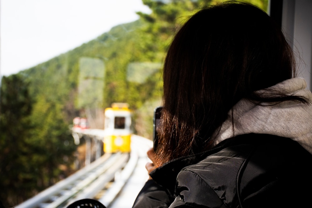 ผู้หญิงมองออกไปนอกหน้าต่างรถไฟในเกาหลีใต้ ที่เที่ยวเกาหลี