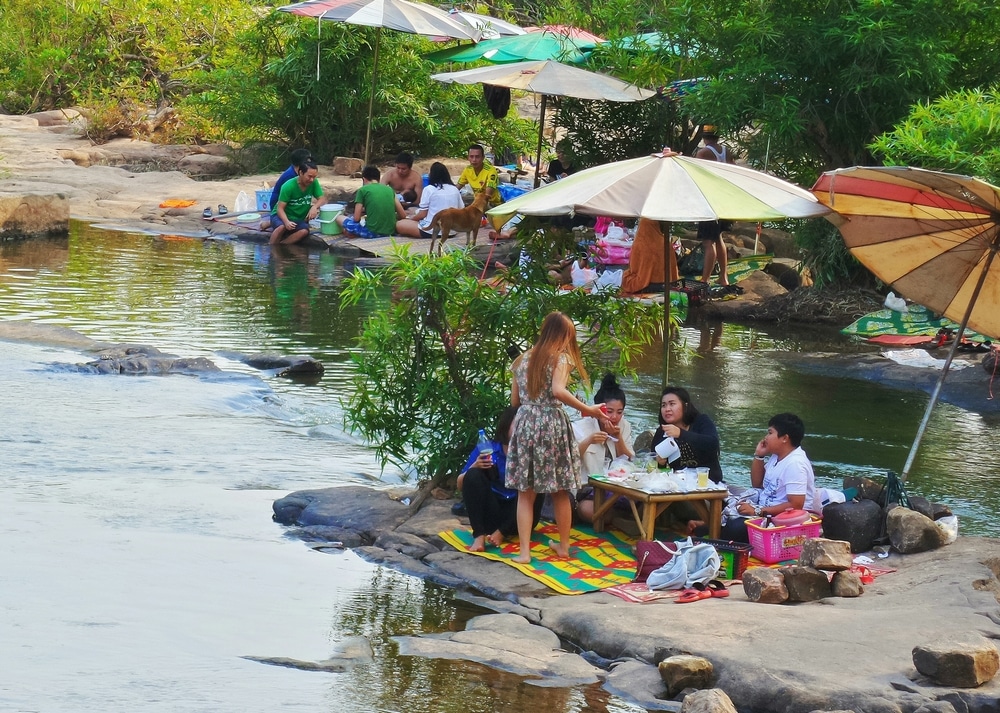 กลุ่มคนที่นั่งอยู่ใกล้แม่น้ำใน สถานที่ท่องเที่ยวพิษณุโลก ที่เที่ยวพิษณุโลก