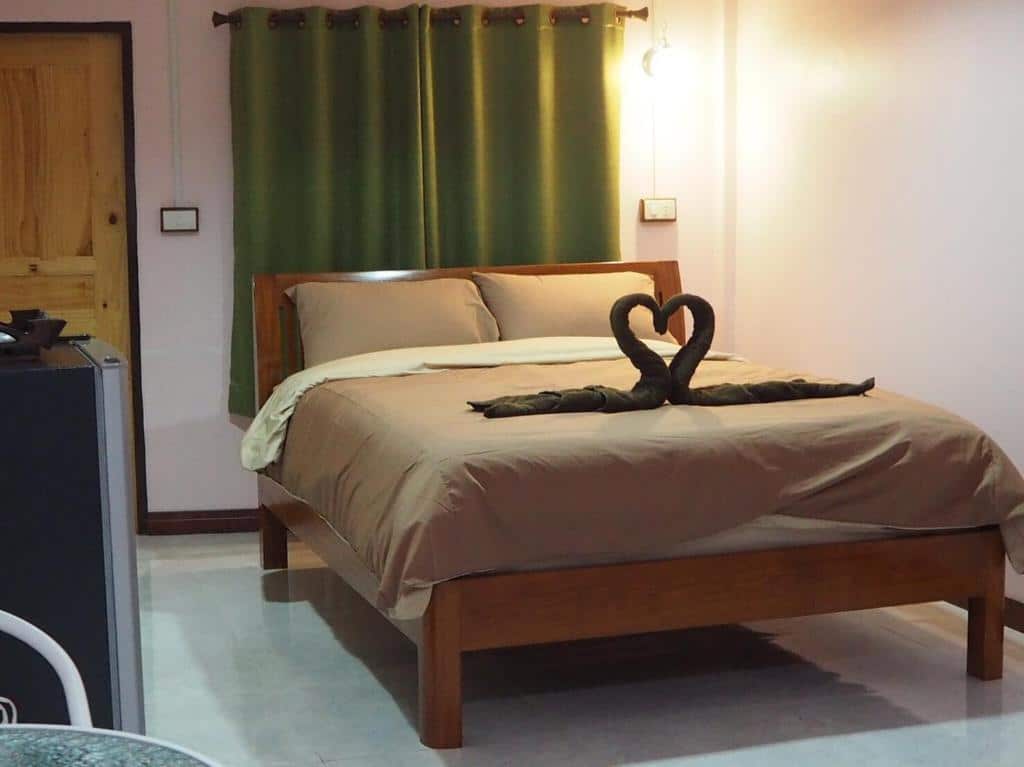 ห้องนอนเล็กๆ ที่มีเตียงและโต๊ะเล็กๆ อ่างทองที่พัก