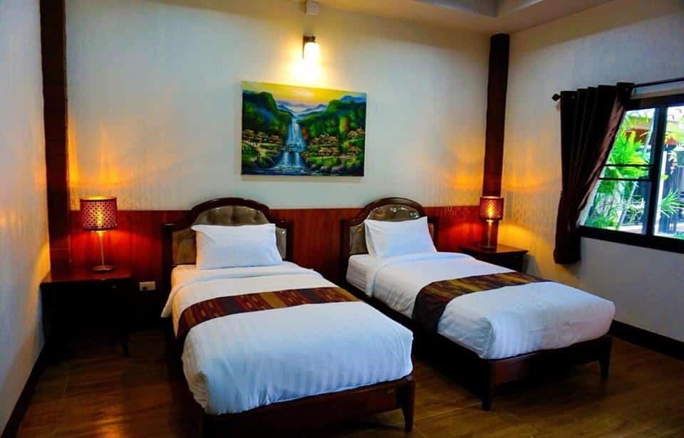 โรงแรมจอมทอง : สองเตียงในห้องที่มีพื้นไม้ที่โรงแรมจอมทองท