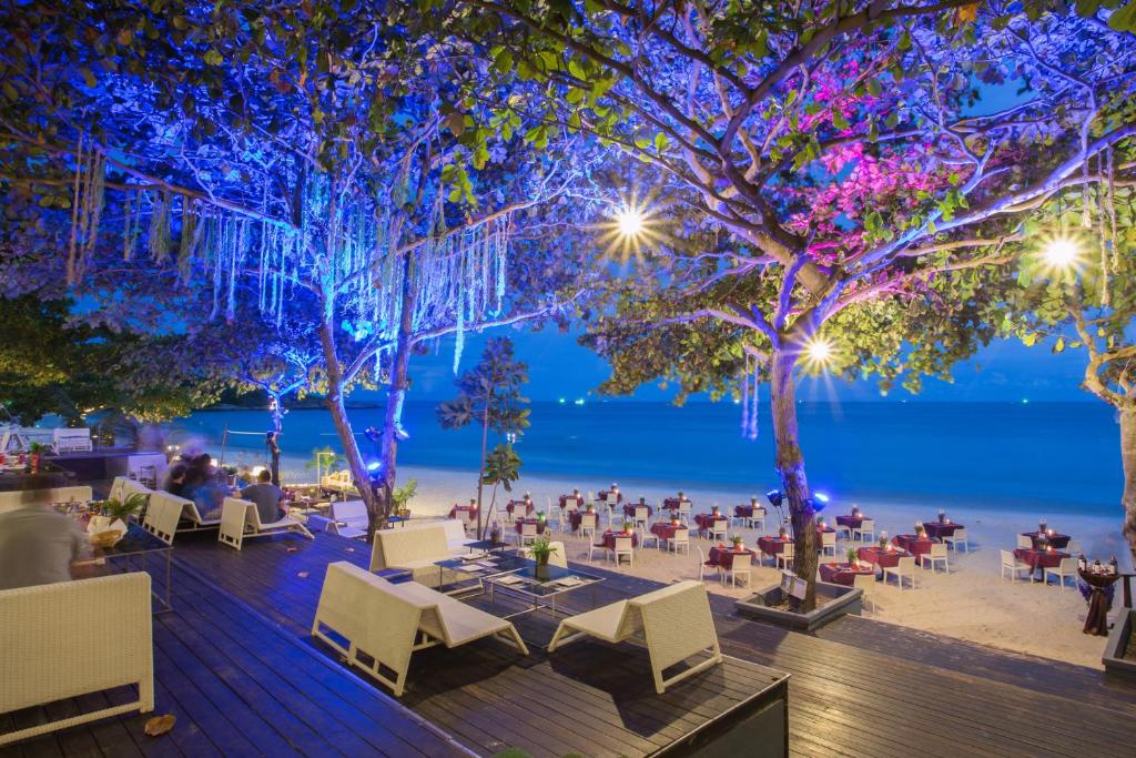 ร้านอาหารพร้อมโต๊ะและเก้าอี้บนชายหาดตอนกลางคืน ที่พักหาดทรายแก้ว