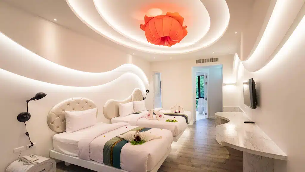 ห้องที่มีเตียงสองเตียงและโคมไฟบนเพดาน หาดทรายแก้วรีสอร์ท
