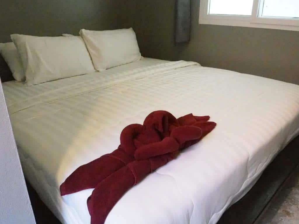 เตียงในห้องที่มีผ้าเช็ดตัวอยู่ หาดทรายแก้วรีสอร์ท