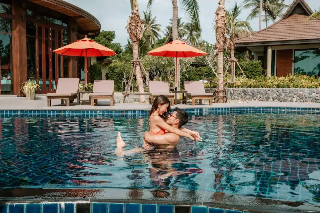 คู่รักในสระว่ายน้ำที่รีสอร์ทแห่งหนึ่งในจังหวัดภูเก็ต ประเทศไทย ที่พักขนอมติดทะเล