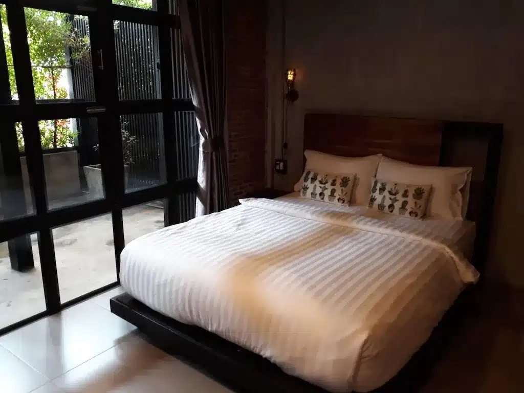 เตียงในห้องที่มีหน้าต่างบานใหญ่ที่โรงแรมลาดพร้าว ที่พักลาดพร้าว