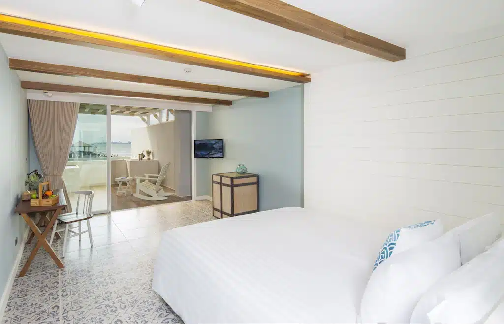 ห้องนอนริมชายหาดพร้อมเตียงสีขาวและวิวทะเลในชลบุรี ประเทศไทย ที่พักบางเสร่