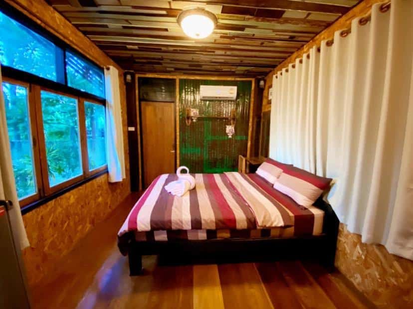 กระท่อมไม้พร้อมเตียงและหน้าต่าง ที่พักวังน้ำเขียว