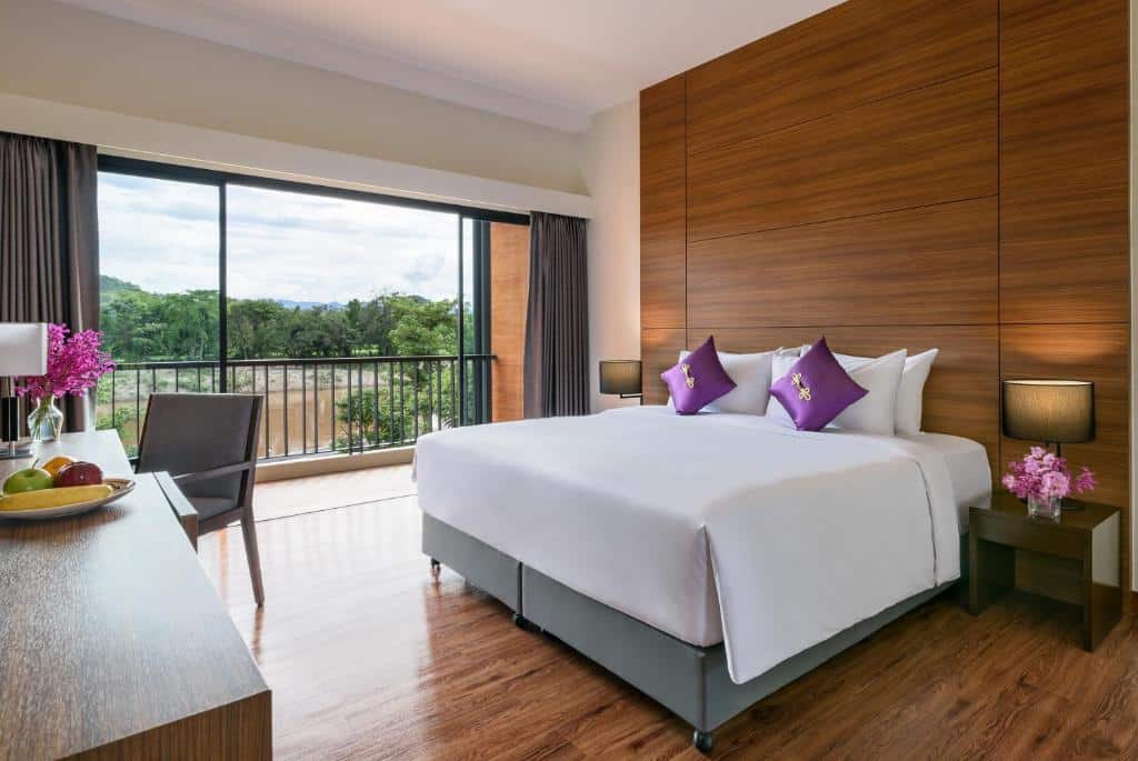 ห้องพักในโรงแรมที่มีเตียงขนาดใหญ่และหมอนสีม่วงตั้งอยู่ในน่านที่เที่ยว ที่พักบนดอยแม่สลอง