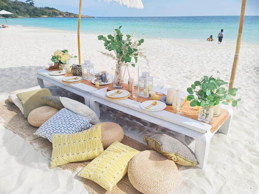 โต๊ะที่จัดไว้บนชายหาดใต้ร่ม ที่พักหาดทรายแก้ว