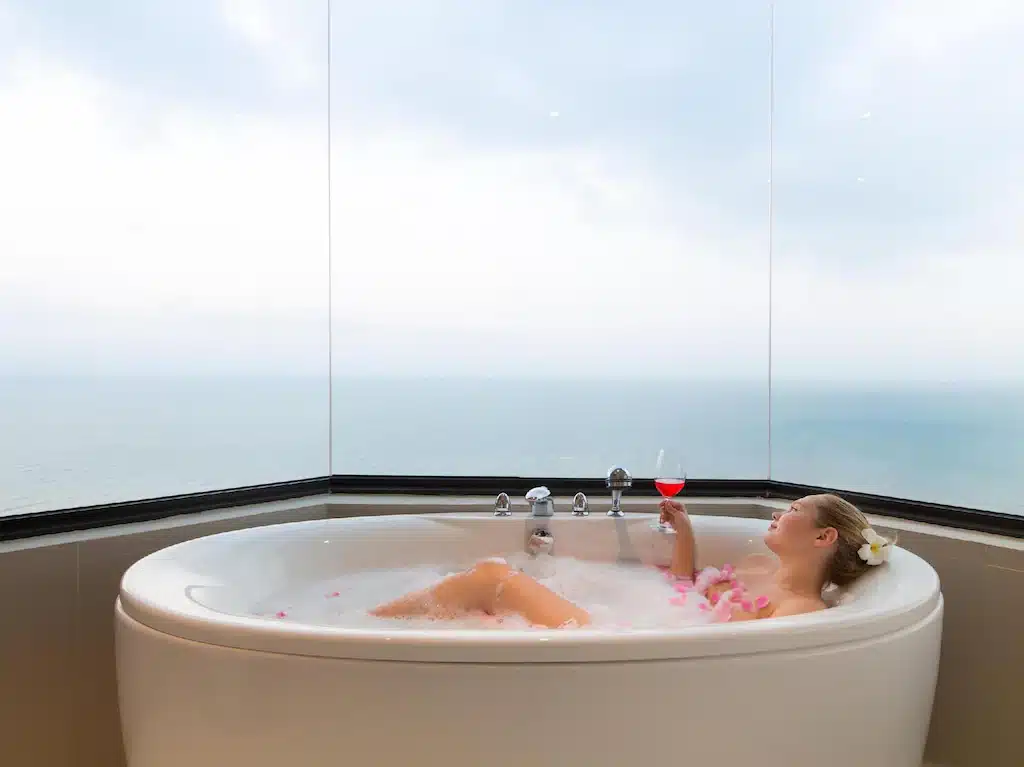 ผู้หญิงกำลังผ่อนคลายในอ่างอาบน้ำสุดหรูพร้อมชมวิวทะเลที่รีสอร์ทระดับ 5 ดาว ที่พักแสมสาร 5 ดาว 