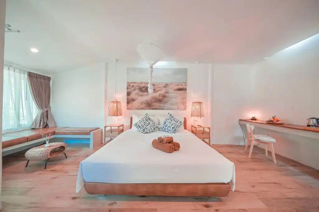 ห้องนอนสีขาวพร้อมพื้นไม้และเตียงไม้ เกาะลันตาที่พัก