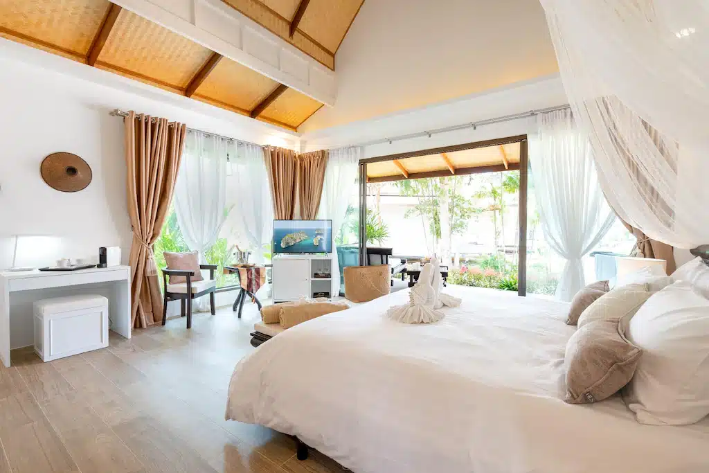 ห้องนอนที่มีเตียงสีขาวและมีหลังคาคลุมอยู่ ที่พักเกาะลันตา