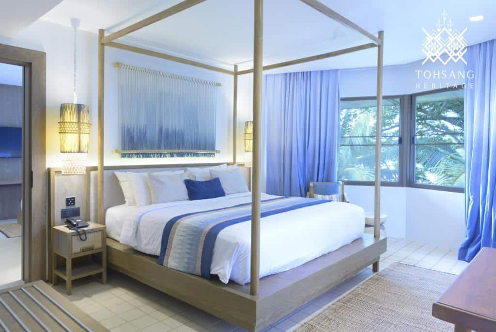 ห้องนอนพร้อมเตียงสี่เสาและผ้าม่านสีฟ้า ที่เที่ยวอุบลราชธานี