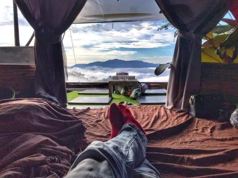 เท้าคนนอนอยู่บนเตียงพร้อมชมวิว ที่พักเชียงใหม่บนดอย ภูเขาที่ชลบุรี