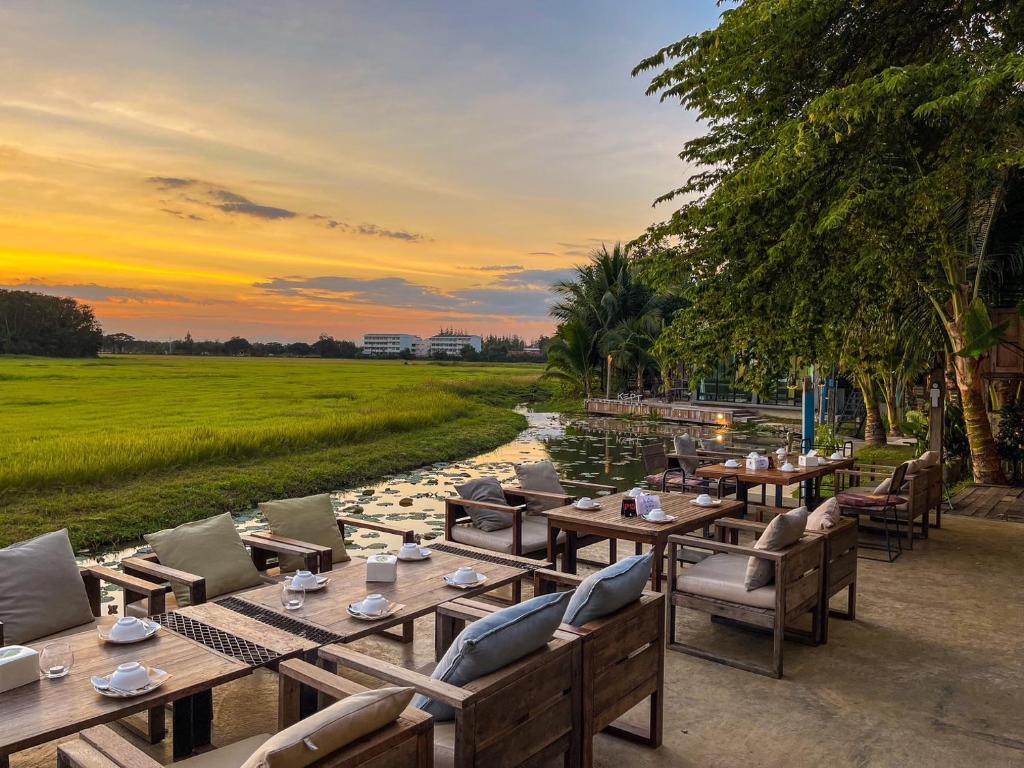 ร้านอาหารพร้อมโต๊ะและเก้าอี้ชมนาข้าวยามพระอาทิตย์ตกที่ชลบุรี โรงแรมลำปาง