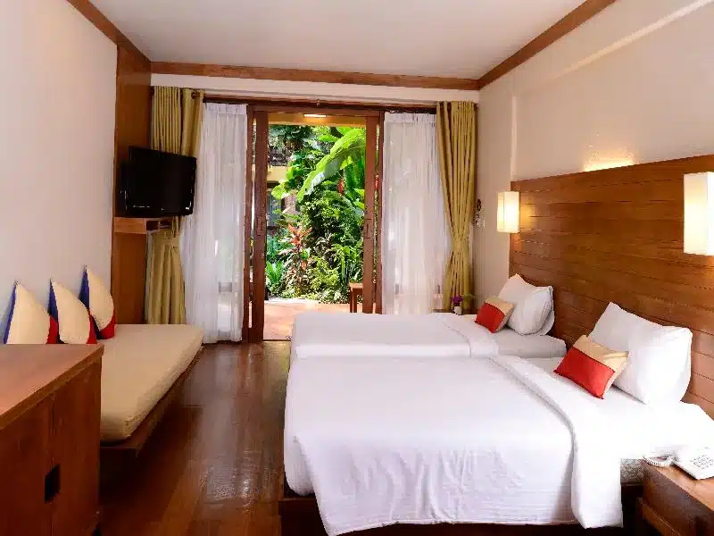 เตียงสองเตียงในห้องที่มีพื้นไม้บนเกาะเกาะลันตา ที่พักหัวหินติดทะเล