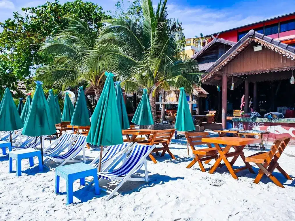ชายหาดที่มีเก้าอี้และร่มบนผืนทราย บ้านพักหาดทรายแก้ว