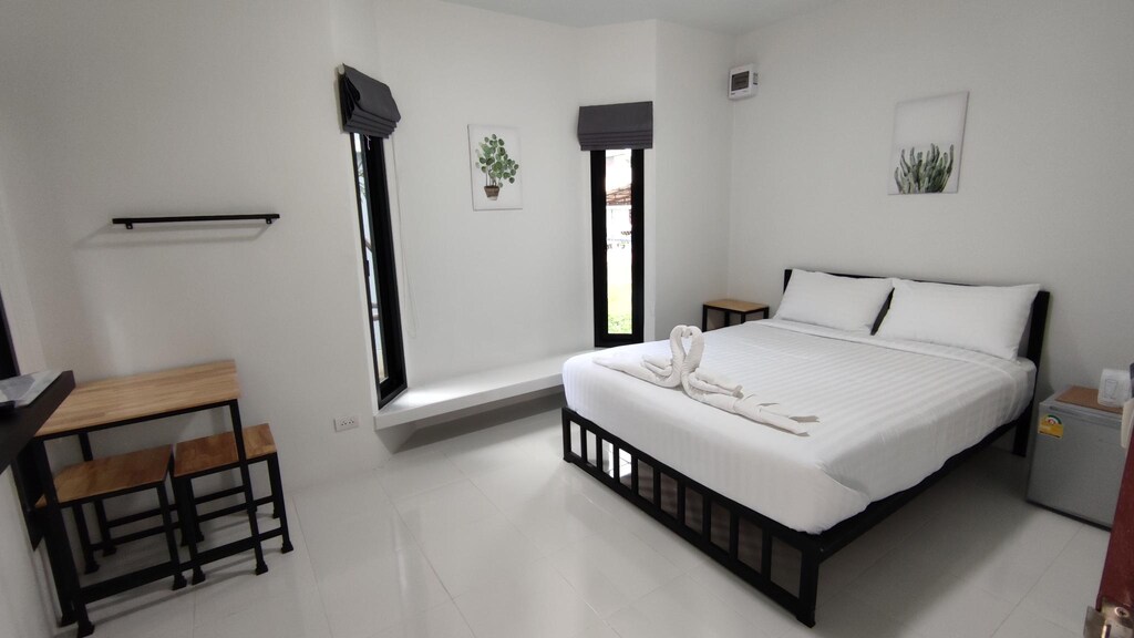 ห้องนอนสีขาวพร้อมเตียงและหน้าต่าง ที่พักอ่างทอง