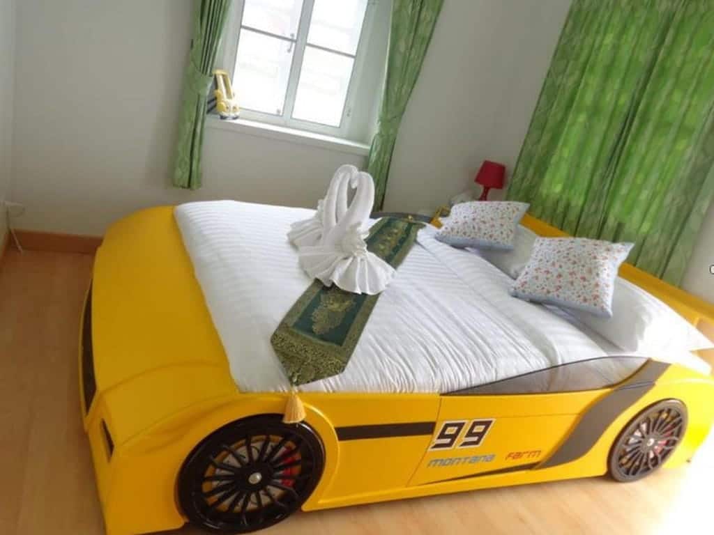 ห้องนอนอันเป็นเอกลักษณ์พร้อมเตียงที่ทำจากรถสีเหลืองใน รีสอร์ทในวังสีเขียว