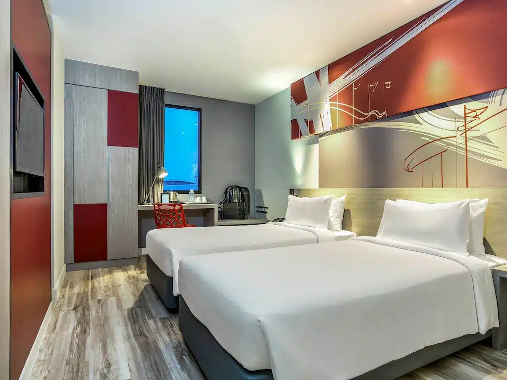 ห้องพักในโรงแรมที่มีสองเตียงและโทรทัศน์ตั้งอยู่ใกล้กับ IMAPAC ในเมืองทองธานี ที่พักใกล้อิมแพคเมืองทองธานี