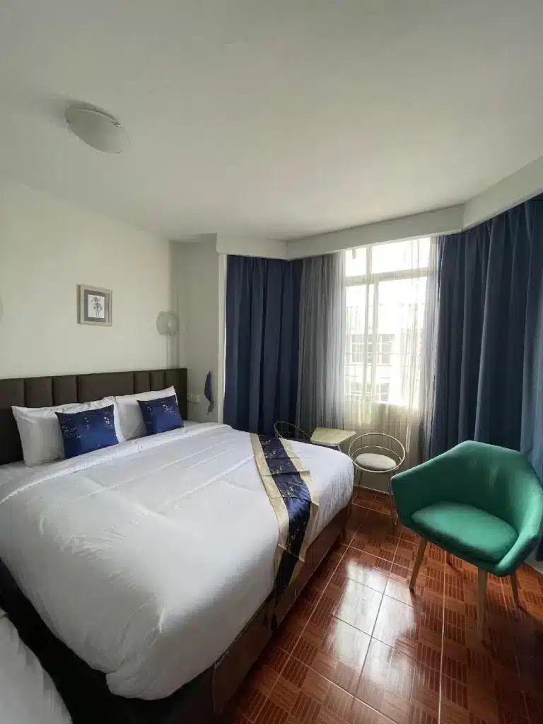 ห้องพักโรงแรมที่มีเตียงสองเตียงและเก้าอี้สี ที่พักใกล้อิมแพค