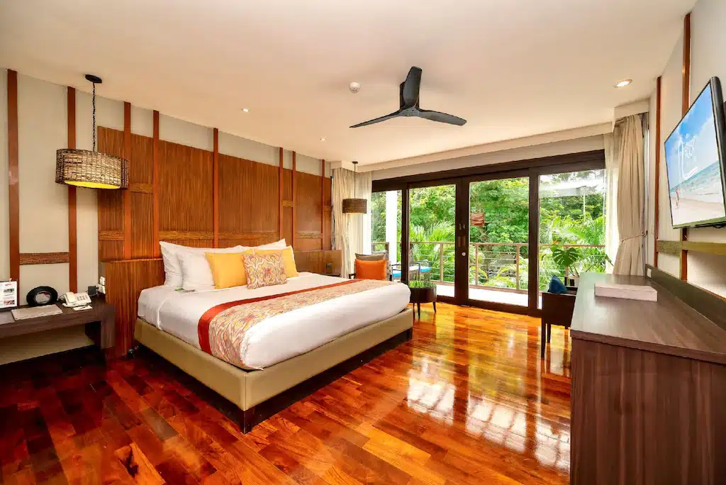 ห้องที่มีพื้นไม้และเตียงขนาดใหญ่ ที่พักเขาตะเกียบติดทะเล