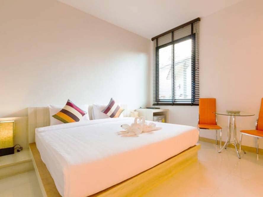 ห้องพักพร้อมเตียงสีขาวและเก้าอี้สีส้ม ราคาไม่แพง ในขนอม poolvilla เขาใหญ่