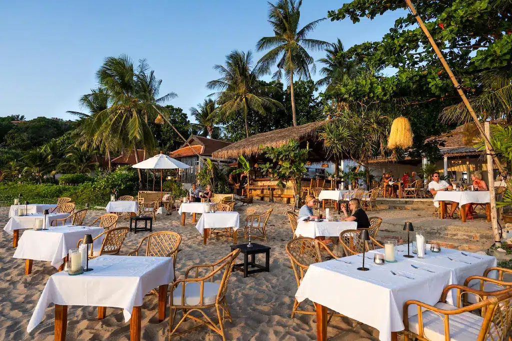 ร้านอาหารริมชายหาดพร้อมโต๊ะและเก้าอี้บนพื้นทราย ที่พักเกาะลันตา