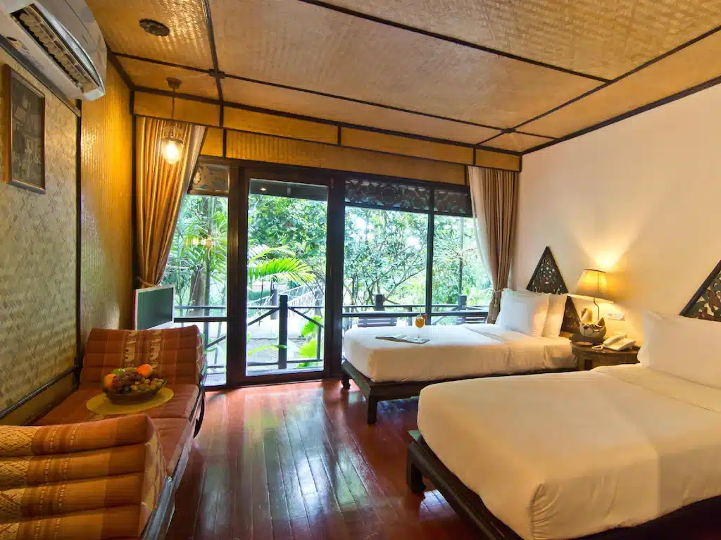 เตียง 2 เตียงในห้องพื้นไม้ในแหล่งท่องเที่ยวของชลบุรี ที่พักลําปางในเมือง
